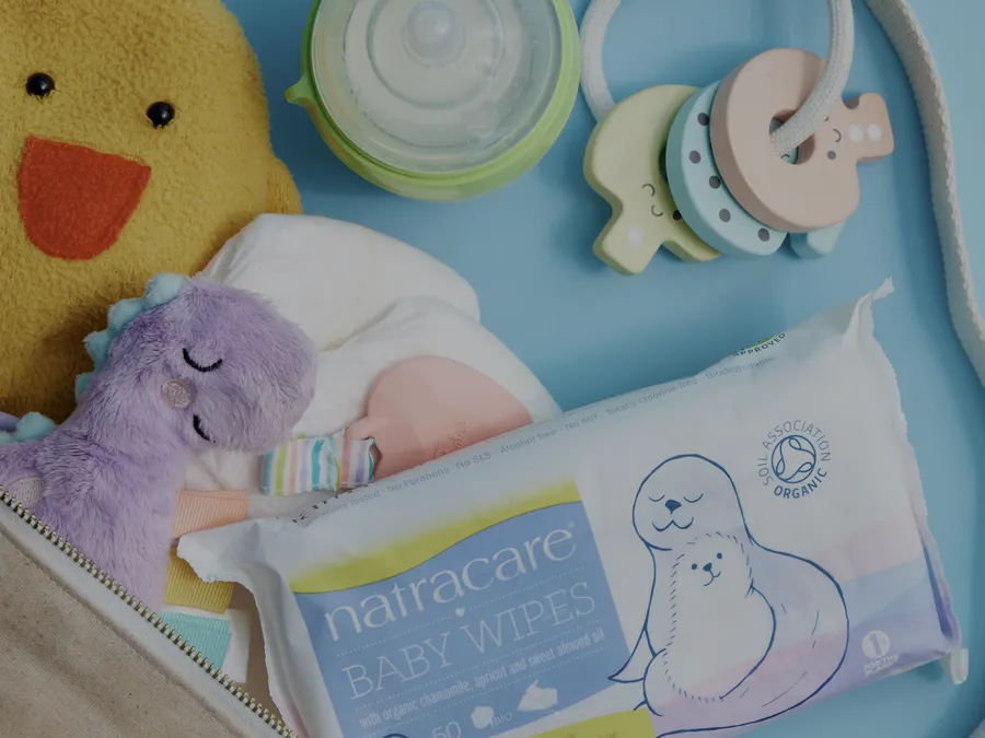 Baby wipes, diapers, and soft toys packed inside an open bag