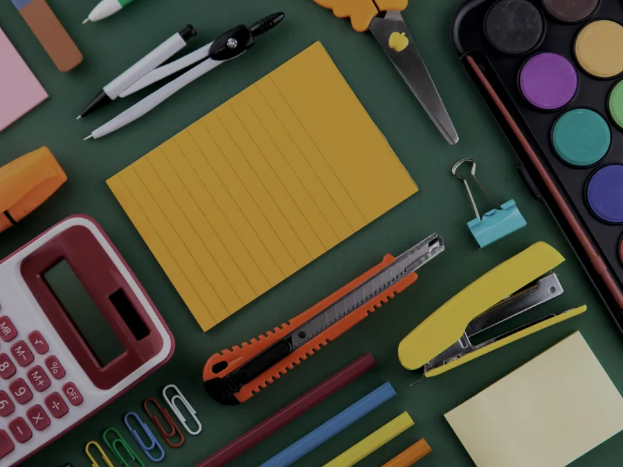 Stationery and craft supplies including a calculator, scissors, and paints
