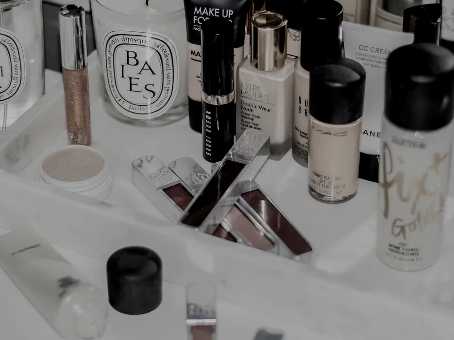 Skincare, makeup, and fragrance bottles arranged on a bathroom vanity tray