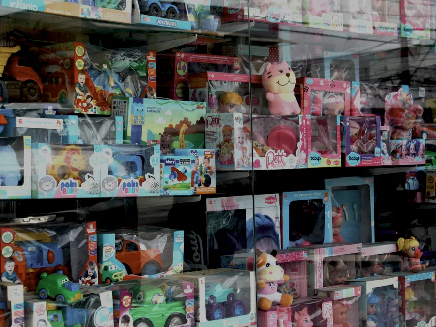 Shelves of boxed toys and games displayed behind a shop window
